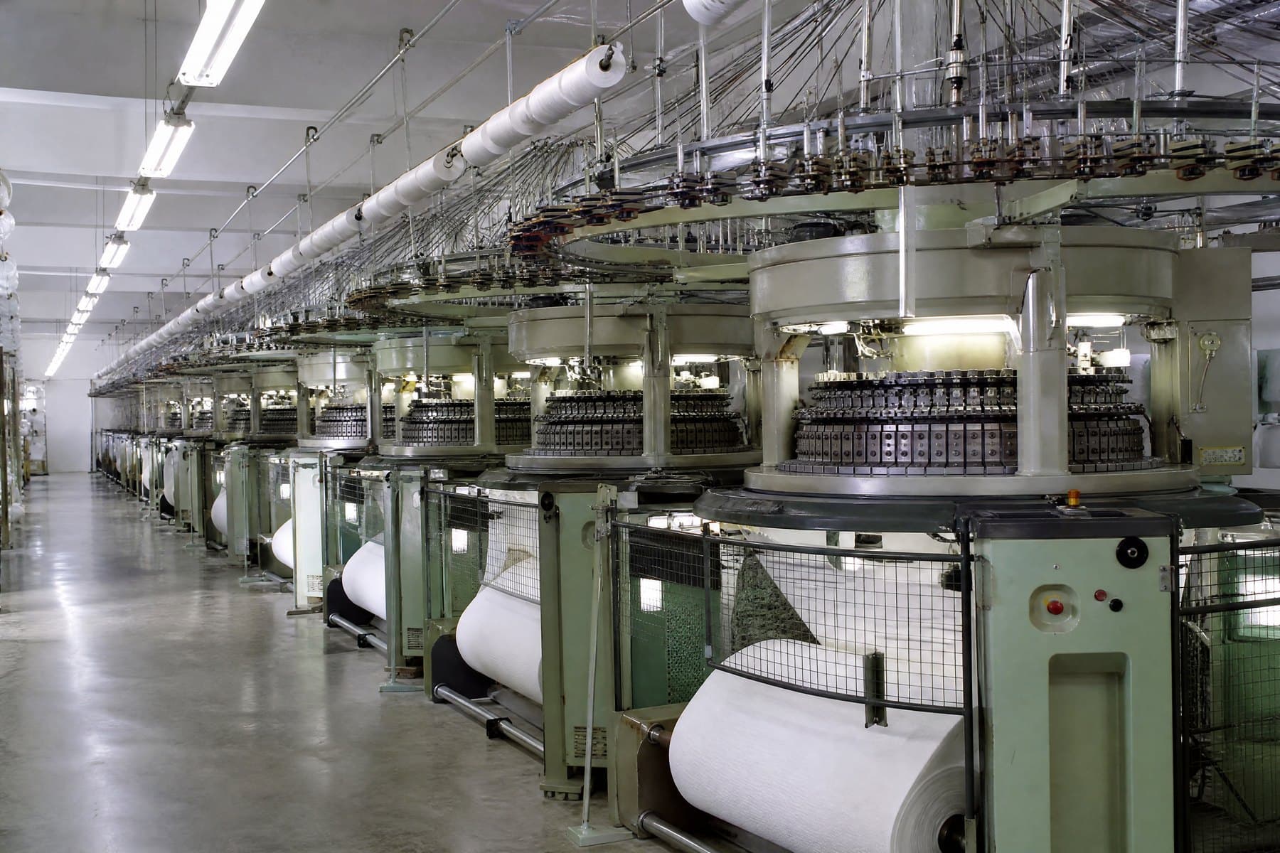 A hall of circular knitting machines forming tubular jersey fabric
