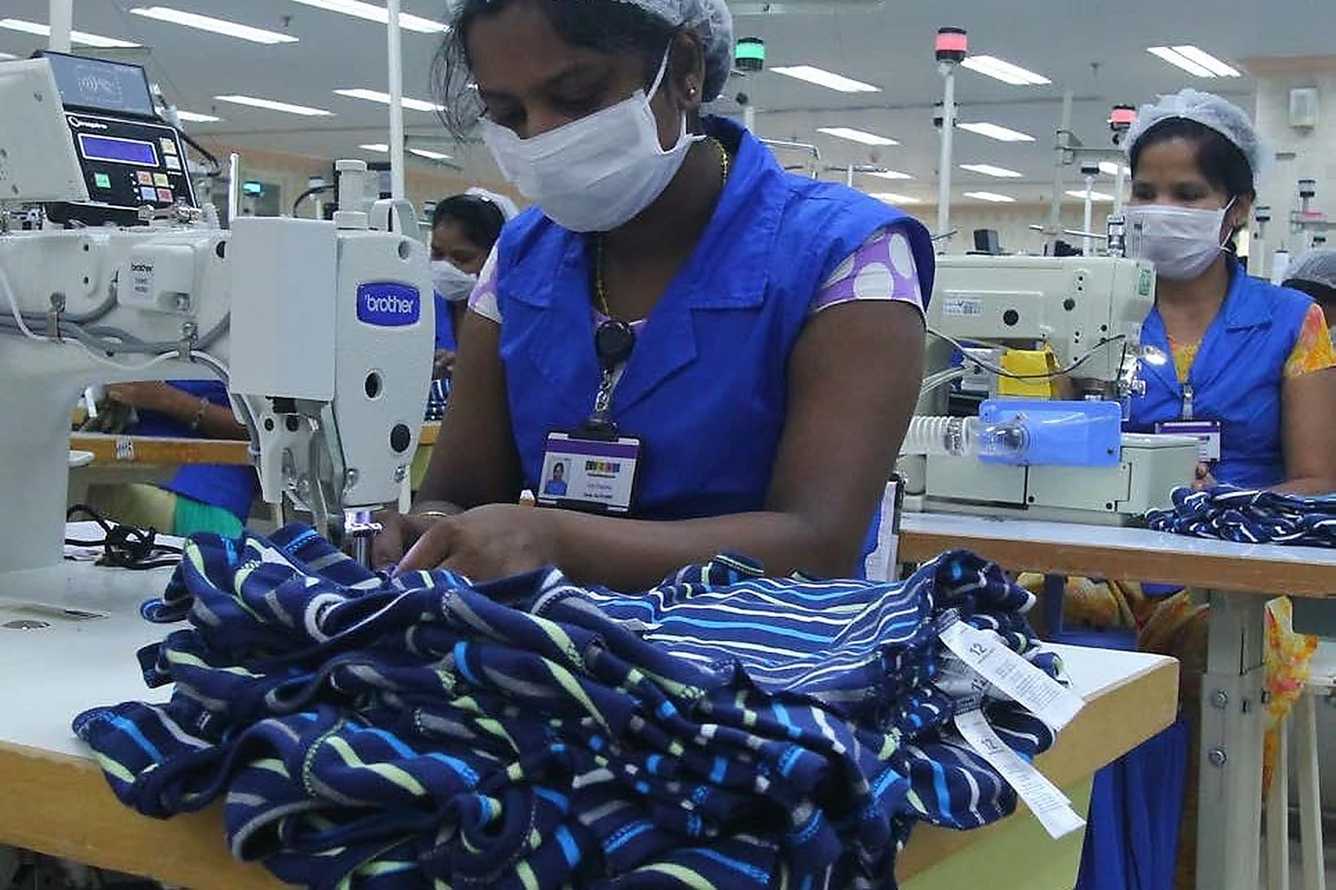 An operator checking finished garments at the machine