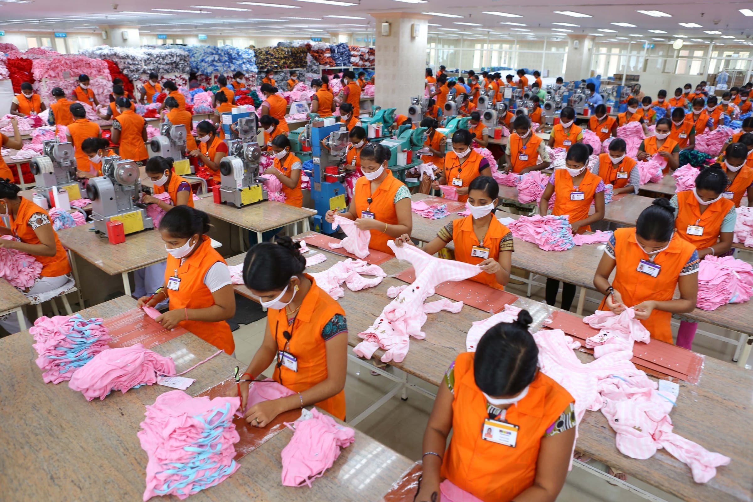 Sewing floor at Kizhakkambalam, with operators assembling infant garments at long benches