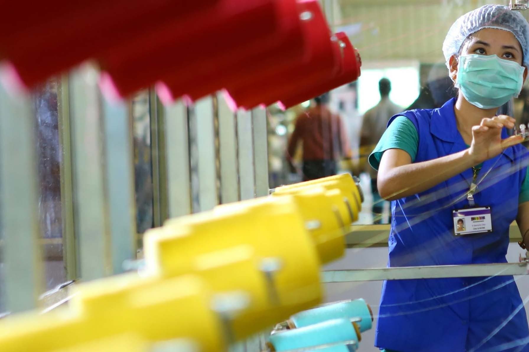 An operator at a machine threaded with cones of yarn